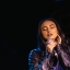 Leah Weller holding a microphone singing with her eyes closed