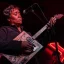 Female blues musician onstage playing cigar box guitar.