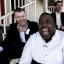 Gabriels promo shot sitting down, wearing suits, laughing.