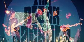 The Black Jackals performing live on stage with bold logo and city skyline graphic overlay.
