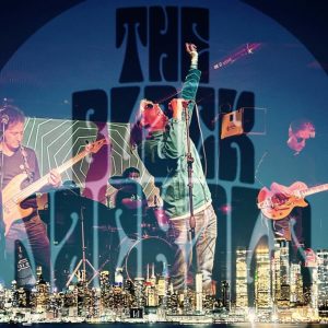 The Black Jackals performing live on stage with bold logo and city skyline graphic overlay.