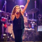 Sandra Mihanovich performing live on stage, singing passionately with microphone, at a concert ahead of her 2025 show at The Cavern Club in Liverpool.