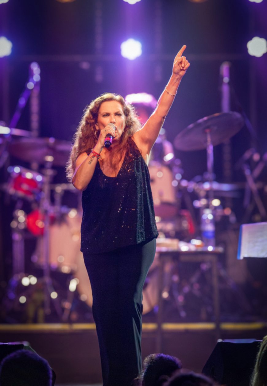 Sandra Mihanovich performing live on stage, singing passionately with microphone, at a concert ahead of her 2025 show at The Cavern Club in Liverpool.