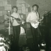 The Beatles performing live at The Cavern Club in Liverpool, featuring John Lennon, Paul McCartney and George Harrison during the band’s early Cavern gigs.